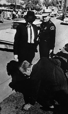Man called Agent examines turf on Dealey Plaza infield
